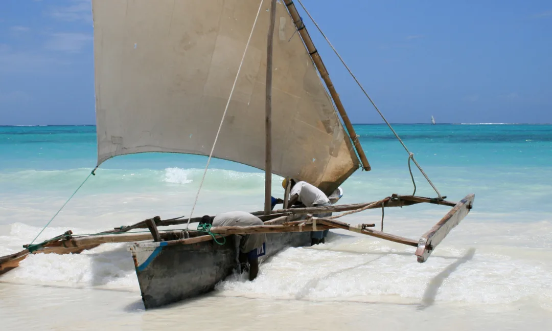 Traditional Zanzibar dhow sailing through turquoise Indian Ocean water